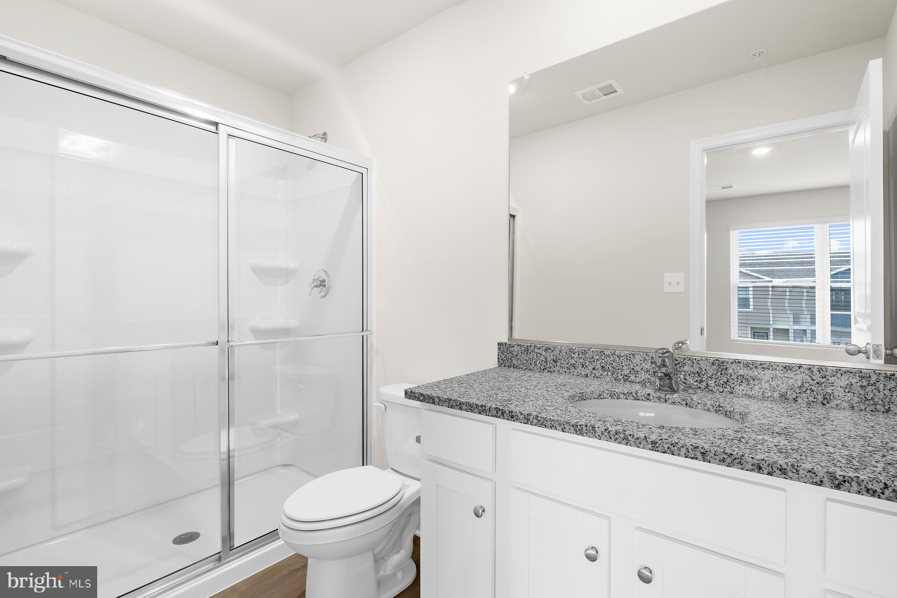 8155 Bartholomew Court Baltimore, MD 21206 - Photo 16 of 19 a bathroom with a granite countertop sink toilet and shower