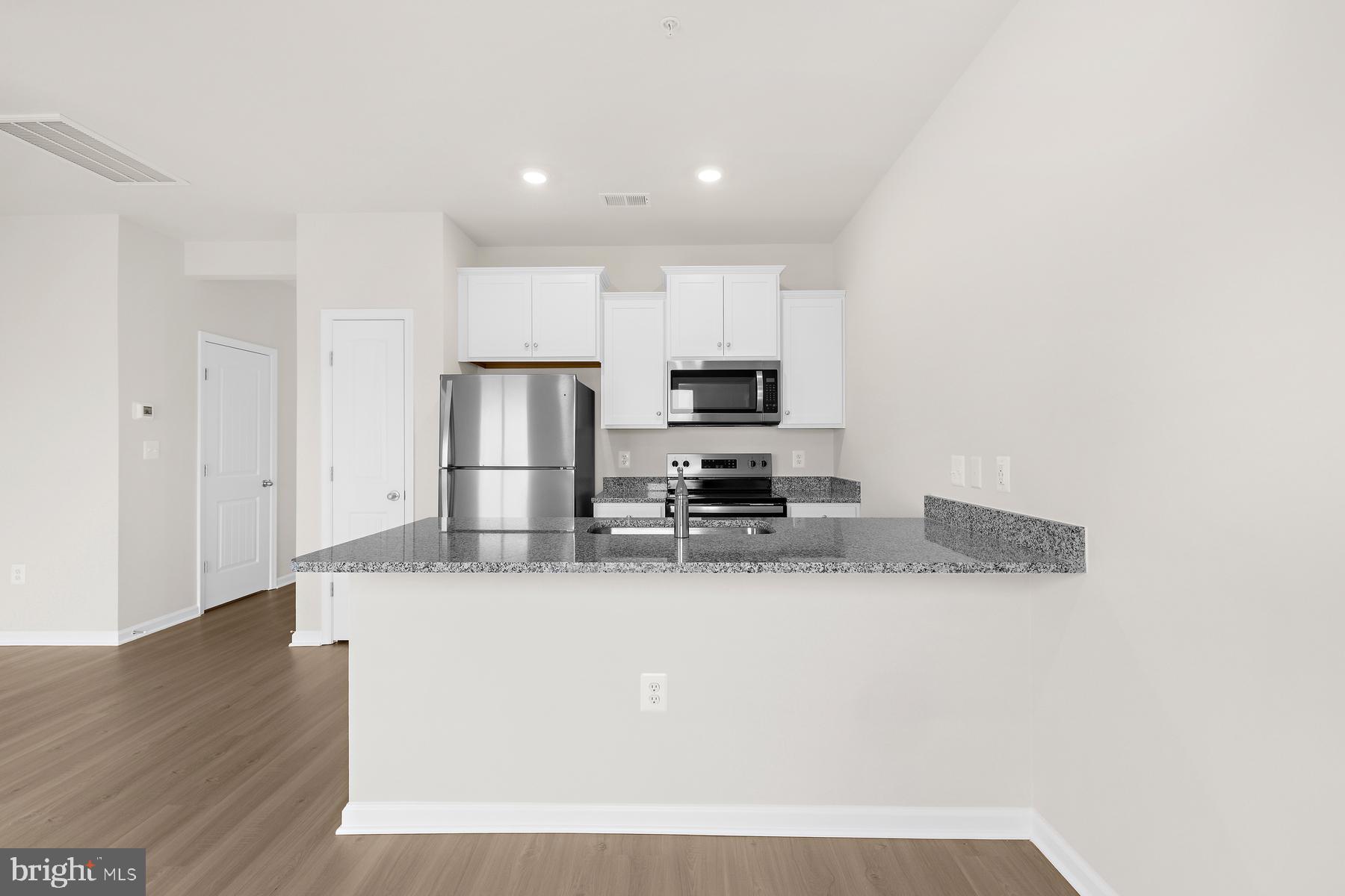 8155 Bartholomew Court Baltimore, MD 21206 - Photo 7 of 19 a kitchen with stainless steel appliances granite countertop a refrigerator a stove a sink and a microwave