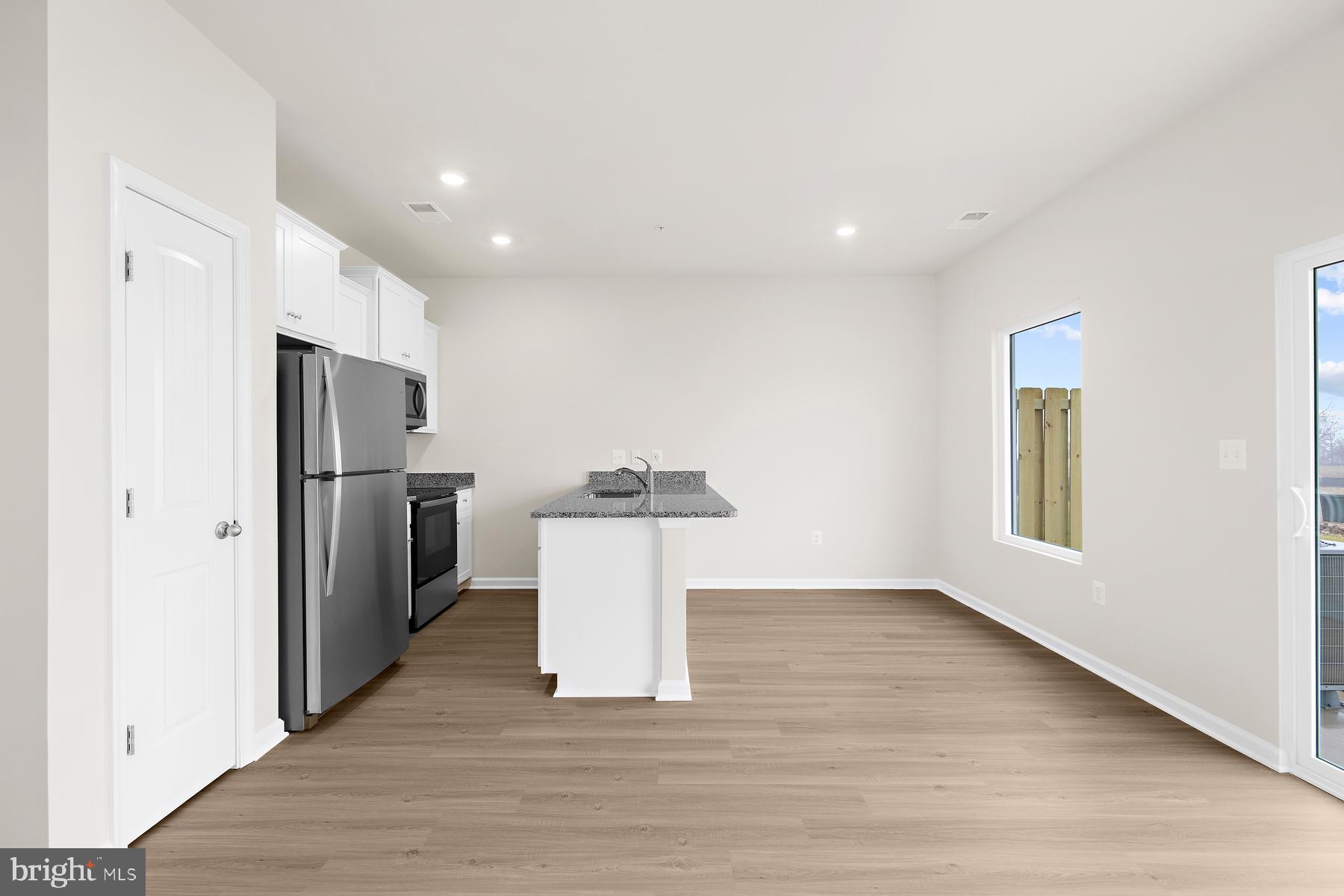 8155 Bartholomew Court Baltimore, MD 21206 - Photo 10 of 19 a view of a kitchen with a sink refrigerator and wooden floor
