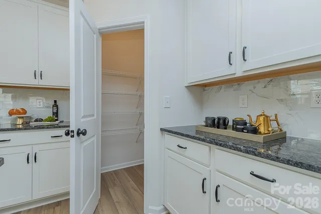 a kitchen with white cabinets and sink