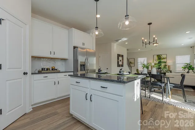 a kitchen with white cabinets and chairs