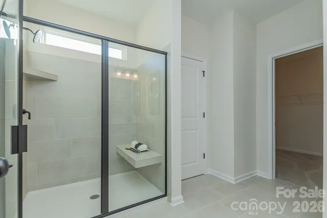 a bathroom with a glass shower door and a mirror