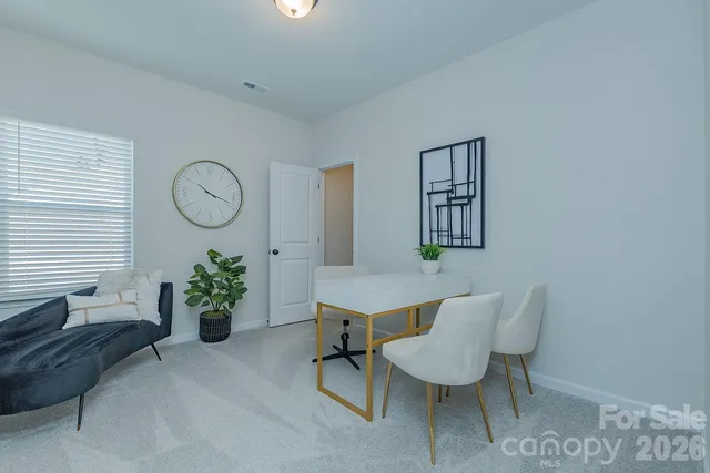 a room with a table chairs and a potted plant