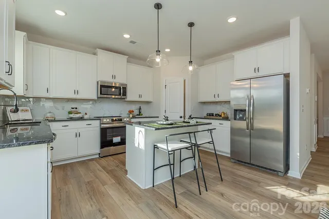 a kitchen with kitchen island granite countertop a counter space stainless steel appliances and cabinets