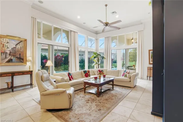 a living room with patio furniture and a large window