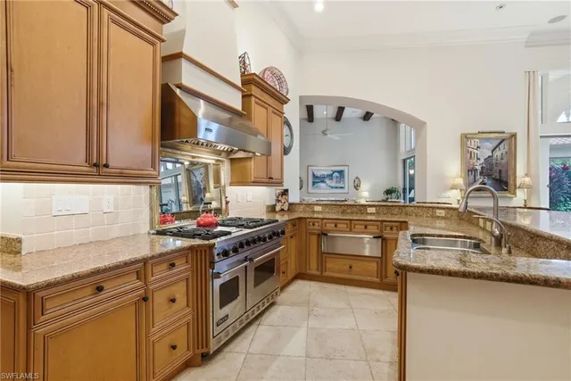 a kitchen with stainless steel appliances granite countertop a sink stove and cabinets