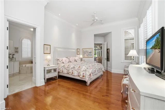a bedroom with a bed and a flat tv screen on dresser