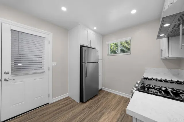a kitchen with a refrigerator and a stove top oven