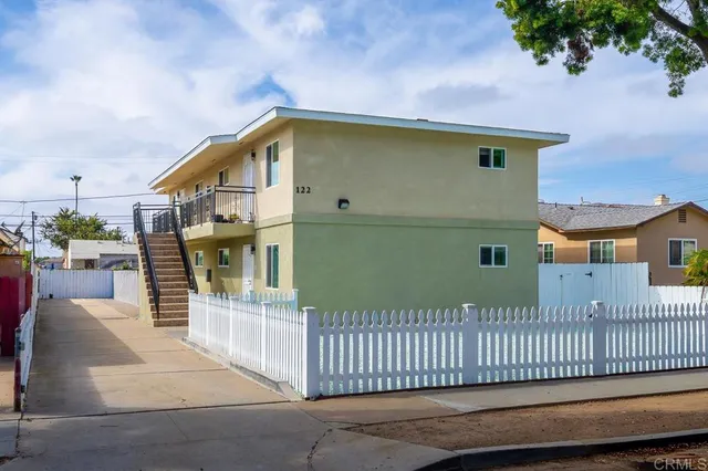 a view of a house with a wooden fence
