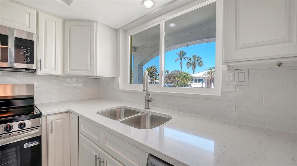 554 Spanish Drive South Longboat Key, FL 34228 - Photo 11 of 72 a kitchen with stainless steel appliances a sink a stove and cabinets