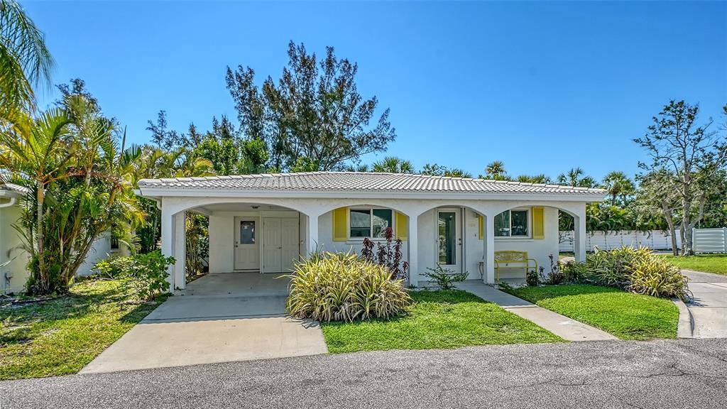 554 Spanish Drive South Longboat Key, FL 34228 - Photo 2 of 72 a front view of a house with a garden