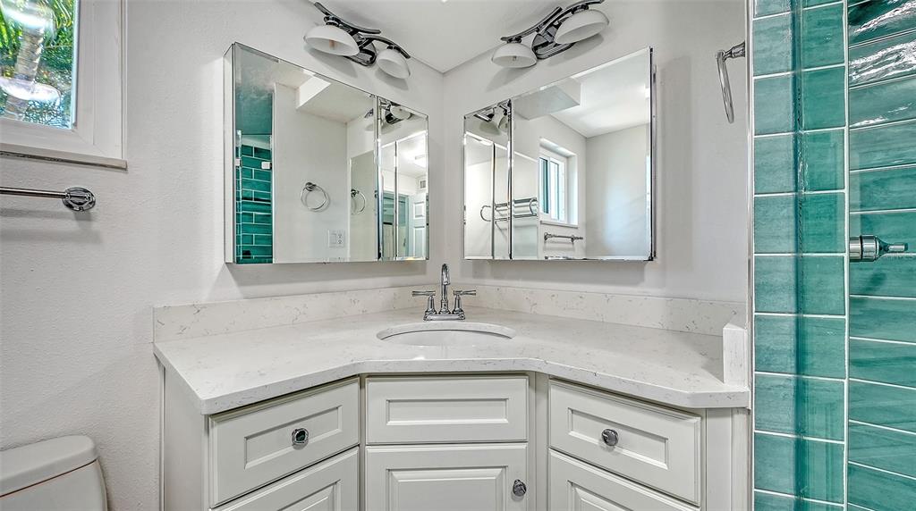 554 Spanish Drive South Longboat Key, FL 34228 - Photo 23 of 72 a bathroom with a granite countertop sink a mirror and a shower