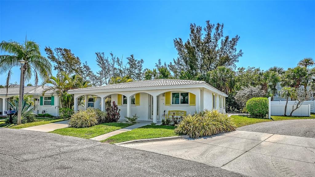 554 Spanish Drive South Longboat Key, FL 34228 - Photo 3 of 72 front view of a house with a yard