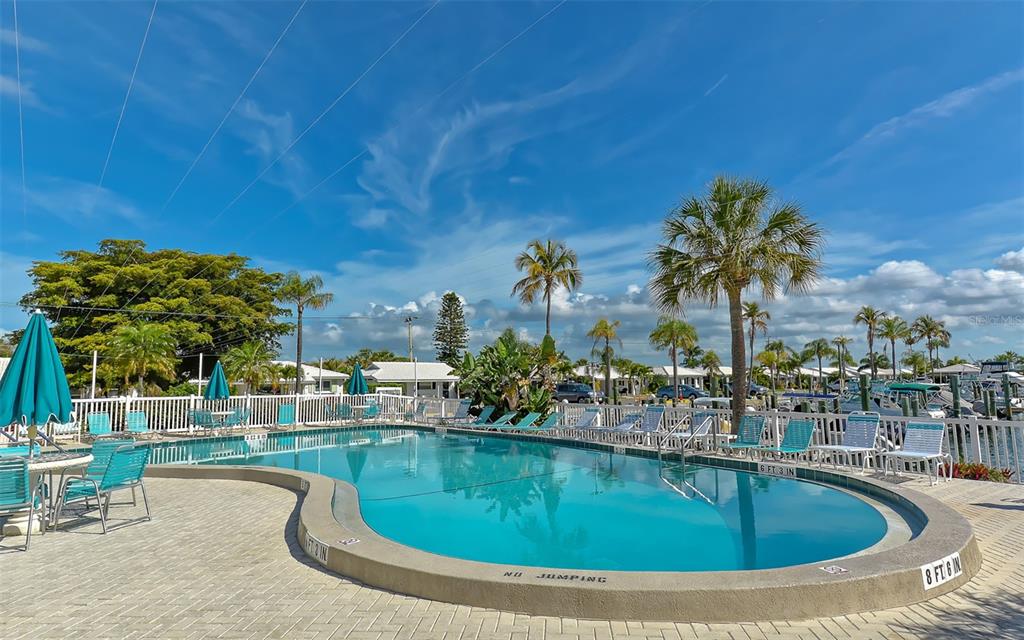 554 Spanish Drive South Longboat Key, FL 34228 - Photo 42 of 72 a swimming pool with outdoor seating and yard