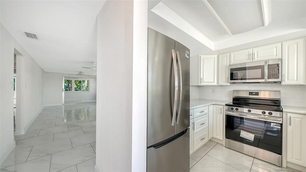 554 Spanish Drive South Longboat Key, FL 34228 - Photo 9 of 72 a kitchen with a refrigerator stove and microwave