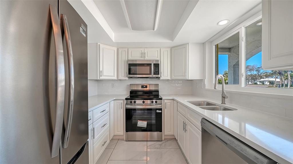 554 Spanish Drive South Longboat Key, FL 34228 - Photo 10 of 72 a kitchen with a sink stove and microwave