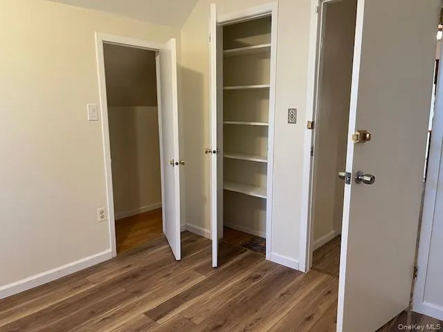 a view of empty room with wooden floor and closet