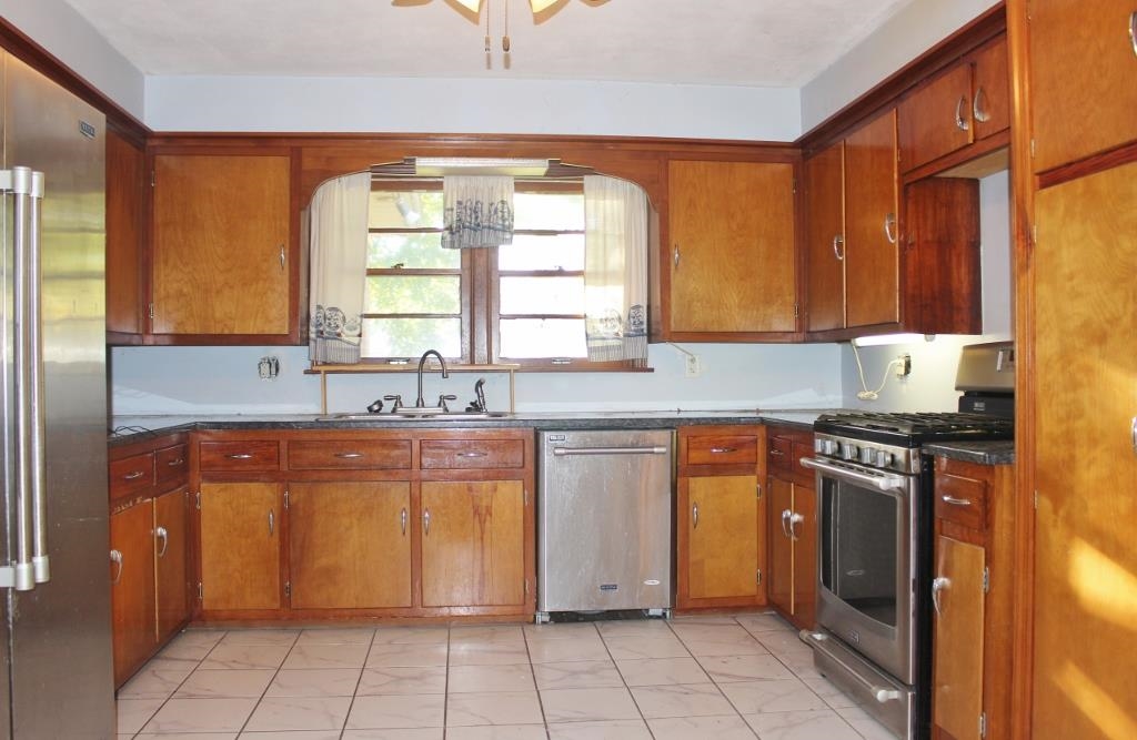 316 West Perry Street Belvidere, IL 61008 - Photo 5 of 21 a kitchen with stainless steel appliances granite countertop a stove a sink and a refrigerator