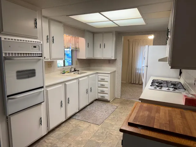 a kitchen with white cabinets and appliances