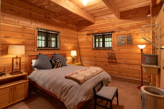 a bedroom with bed and wooden floor