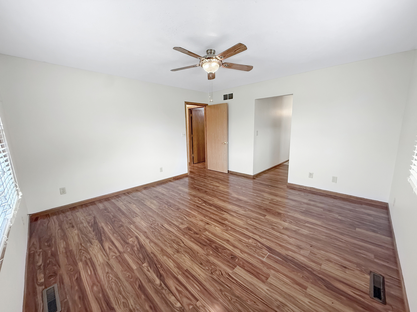 100 Adams Street Ridott, IL 61067 - Photo 11 of 17 an empty room with wooden floor ceiling fan and windows