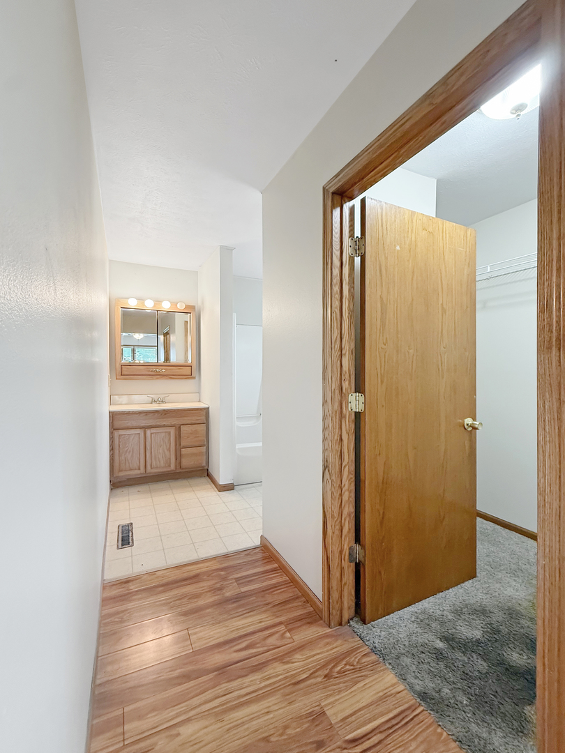 100 Adams Street Ridott, IL 61067 - Photo 12 of 17 a view of a hallway with wooden floor and a bathroom