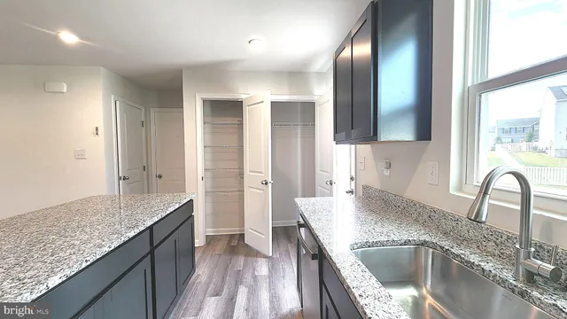 a kitchen with granite countertop a sink a stove and refrigerator