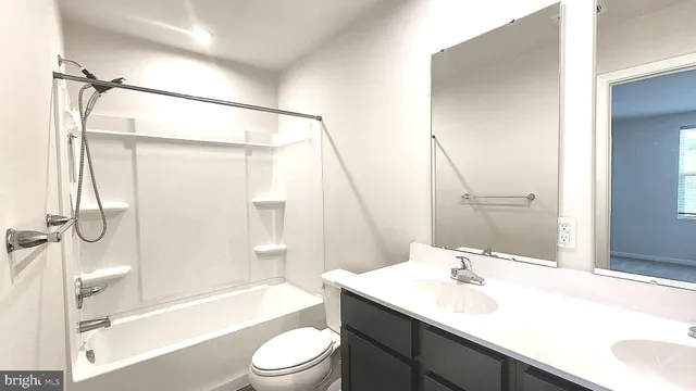 a bathroom with a sink a toilet a mirror and shower