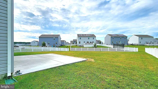 a view of a house with a yard and a large tree