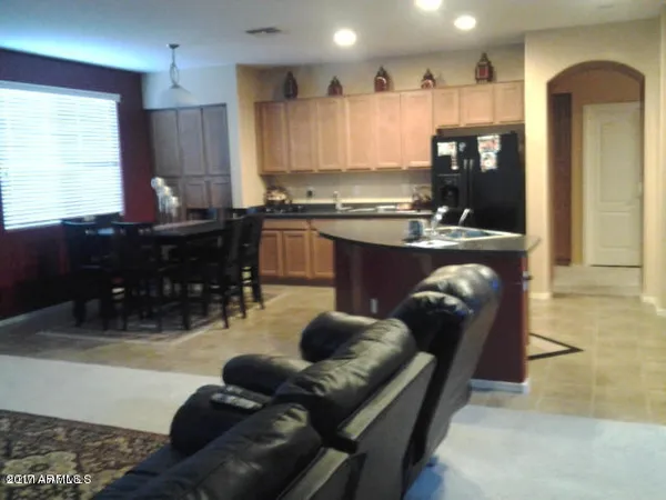 a kitchen with stainless steel appliances granite countertop a refrigerator and a view of living room