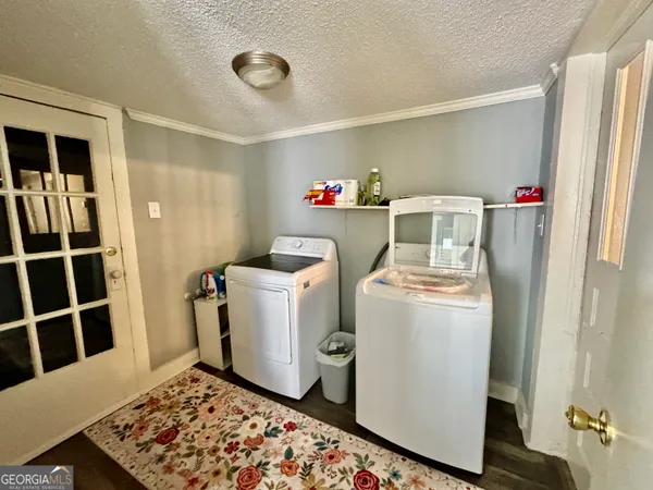 a view of a hallway with wooden floor and a bathroom