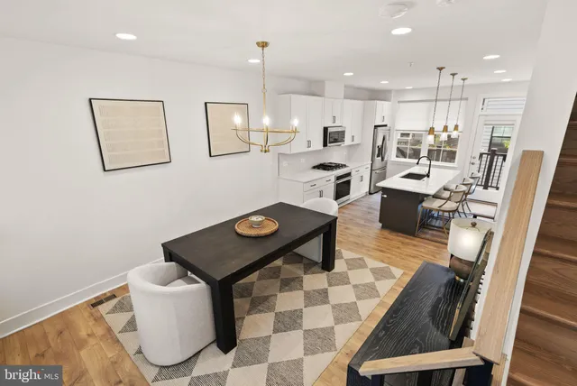 a kitchen with a sink a stove a refrigerator and white cabinets