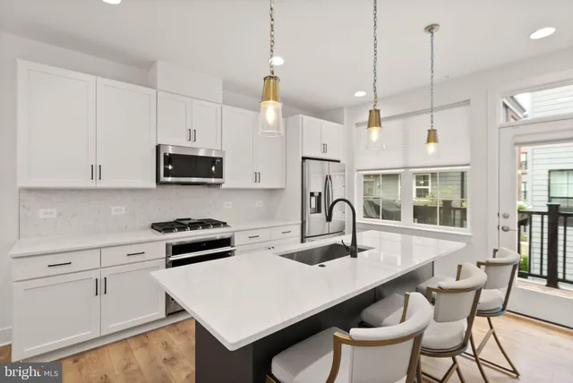 a kitchen with stainless steel appliances kitchen island a sink a stove a microwave and cabinets