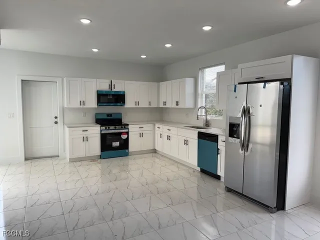 a kitchen with stainless steel appliances granite countertop a refrigerator sink and cabinets