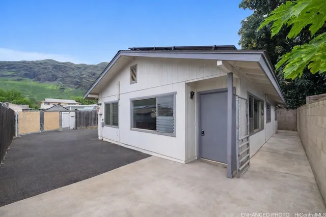 a view of a house with a yard and potted plants
