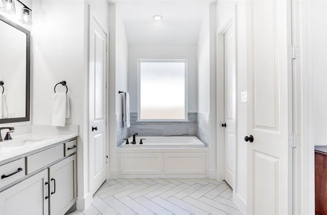 a bathroom with a double vanity sink a mirror and a bathtub