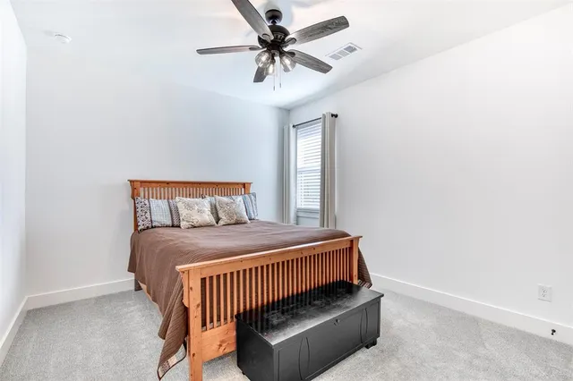 a bedroom with a bed and a ceiling fan
