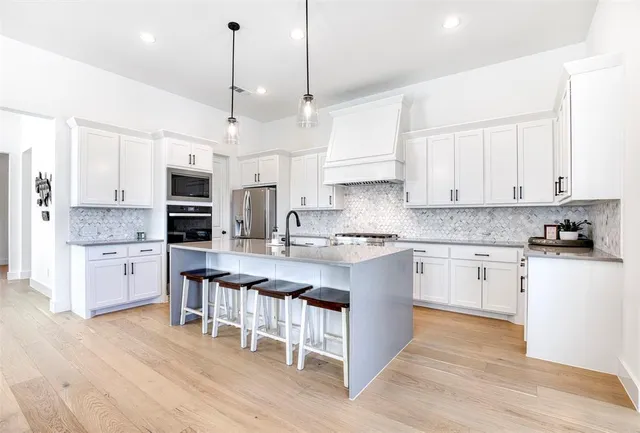 a kitchen with kitchen island granite countertop a sink a center island and cabinets