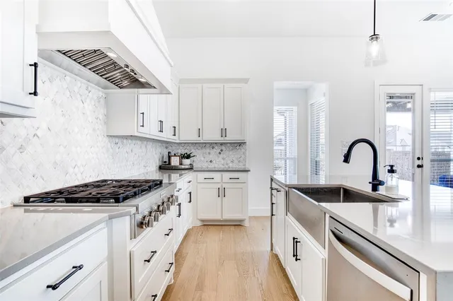 a kitchen with granite countertop a sink stove and cabinets