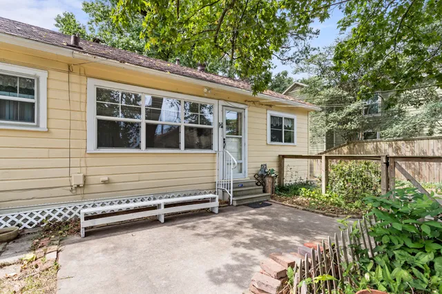 a view of a house with a small yard and wooden fence