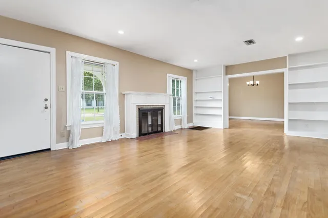 a view of empty room with wooden floor and fireplace