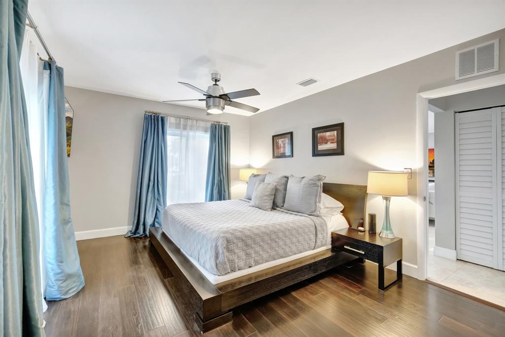 201 Northeast 28th Court Wilton Manors, FL 33334 - Photo 22 of 83 a bedroom with a bed and wooden floor