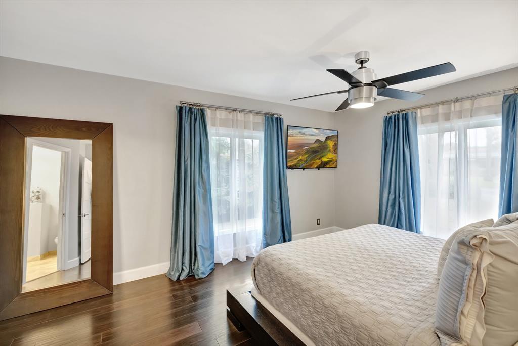 201 Northeast 28th Court Wilton Manors, FL 33334 - Photo 25 of 83 a bedroom with a bed and wooden floor