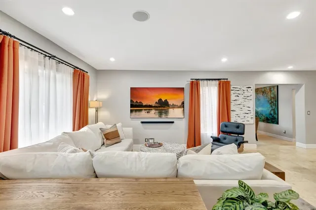 a living room with furniture a large window and a flat screen tv