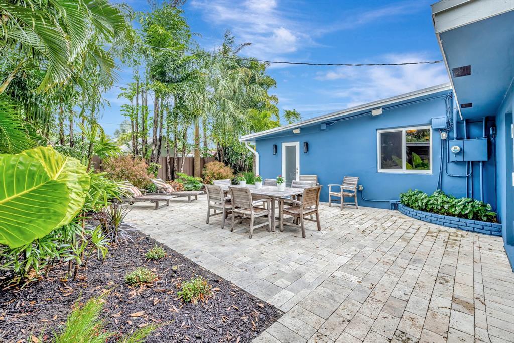 201 Northeast 28th Court Wilton Manors, FL 33334 - Photo 59 of 83 a view of a patio with table and chairs potted plants and floor to ceiling window