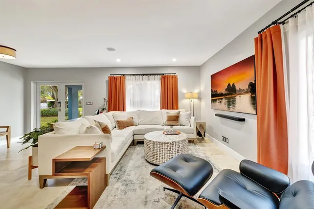 a living room with furniture a rug and a window