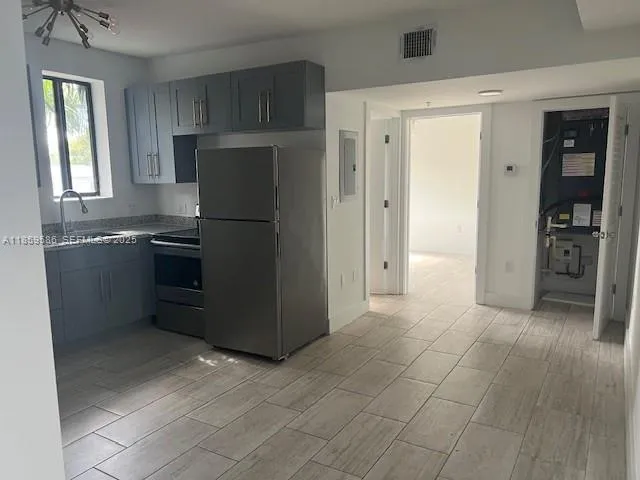 a kitchen with stainless steel appliances granite countertop a refrigerator and a sink