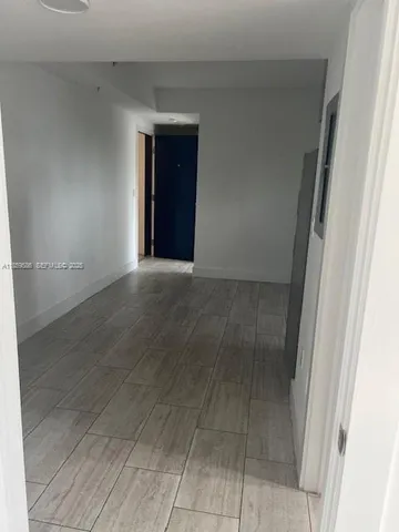 an empty room with wooden floor and cabinet
