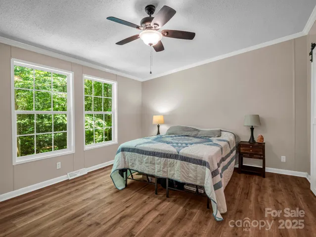 a bedroom with a large bed and a chandelier