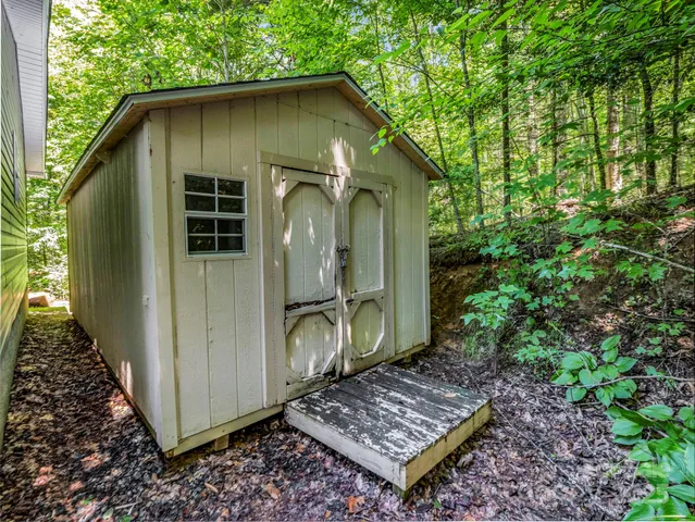 a backyard of a house with a yard and large tree